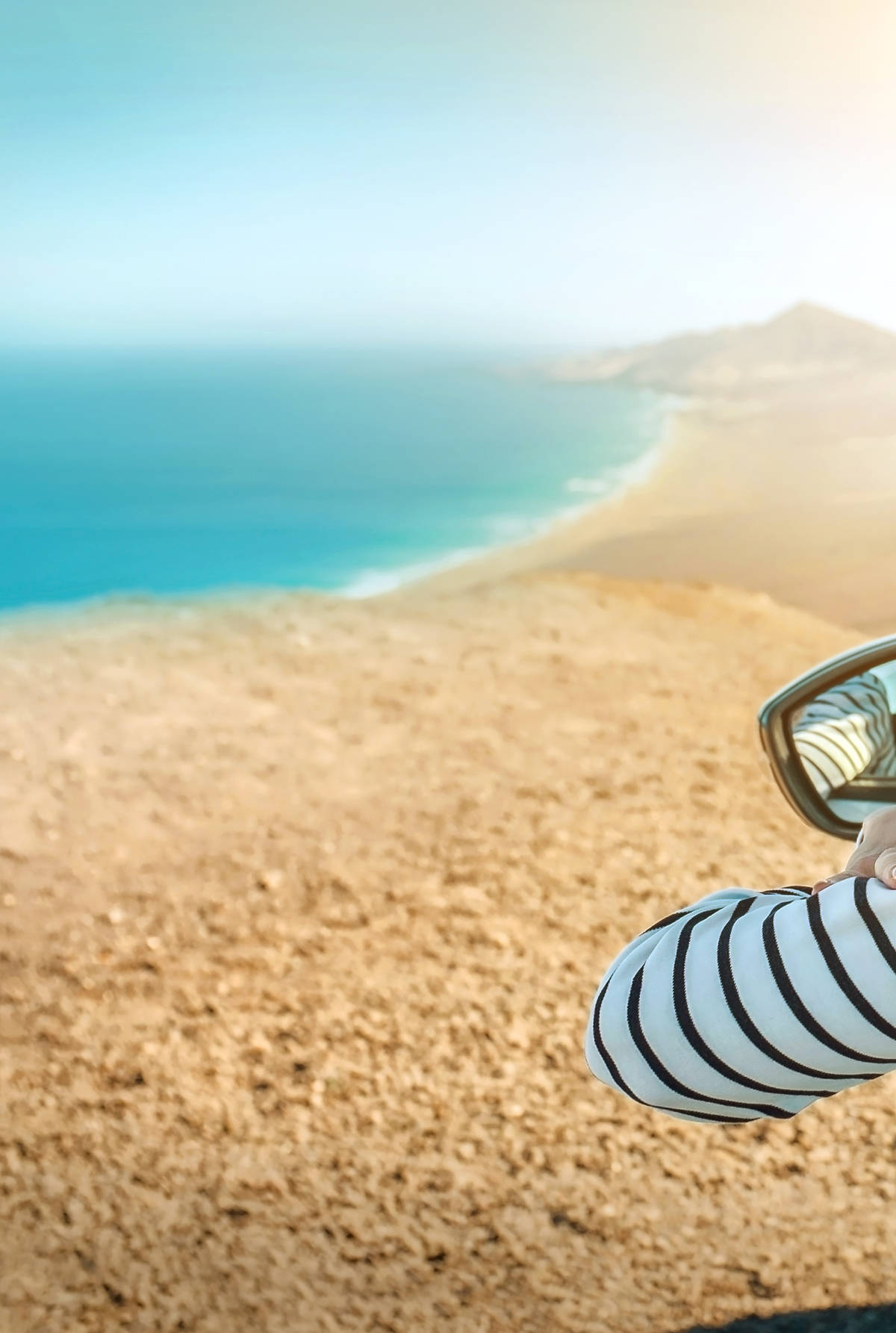 A woman looking out over the beach from her car window